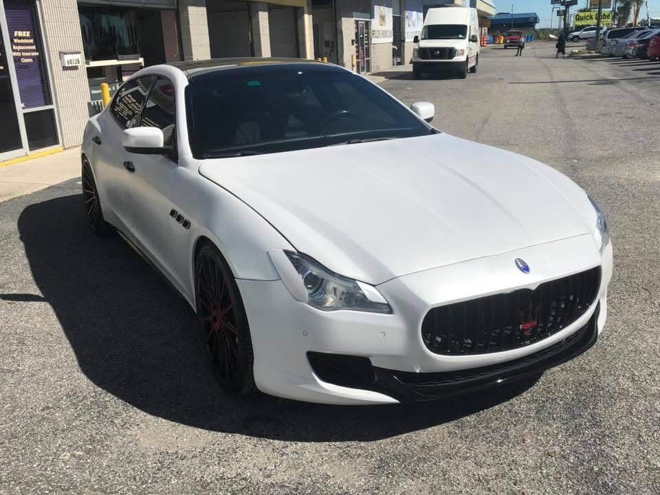 Finished white Maserati Quattroporte parked outside F&R Auto Body on 56th Street in East Tampa